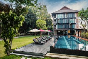 a resort with a pool and chairs and a building at Siripanna Villa Resort & Spa Chiang Mai -SHA Extra Plus in Chiang Mai