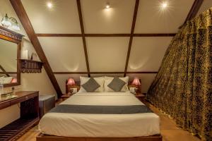 ein Schlafzimmer mit einem großen Bett in einem Zimmer in der Unterkunft SaffronStays Tudor Rose, Panchgani - luxury chalet with beautiful valley views in Panchgani + 10 Fotos