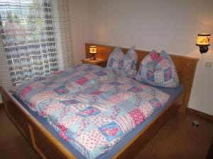 a bed with a quilt and pillows on it at Holiday Home Jung - GBM240 by Interhome in Gröbming
