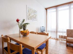 uma mesa de jantar com um vaso de flores sobre ela em Studio Résidence Greppon by Interhome em Les Collons