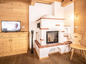KlazenbergにあるChalet Fredis Hütte by Interhomeの暖炉とテレビのあるリビングルーム