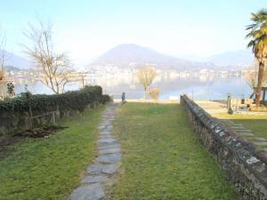 a stone path in front of a body of water at Apartment Lungolago by Interhome in Lavena Ponte Tresa