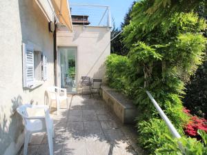 eine Terrasse mit Stühlen und Pflanzen neben einem Gebäude in der Unterkunft Holiday Home Il Roccolo by Interhome in Pettenasco
