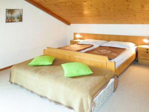 two beds in a room with two green pillows at Apartment Lassnig-1 by Interhome in Arriach
