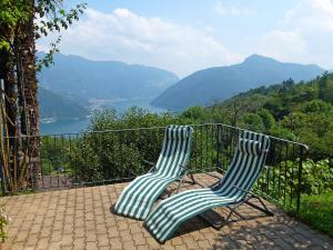 two chairs sitting on a balcony with a view of a lake at Apartment al Ronchetto by Interhome in Carona