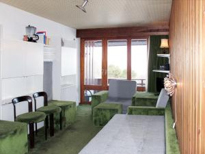 a living room with green chairs and a table at Studio Résidence Velan-2 by Interhome in Les Collons +16 photos