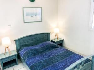 een slaapkamer met een bed en twee lampen op tafels bij Apartment La Palme d'Or-16 by Interhome in Cap d'Agde