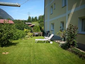 a white chair sitting in the yard of a house at Apartment Kaufmann by Interhome in Tobadill