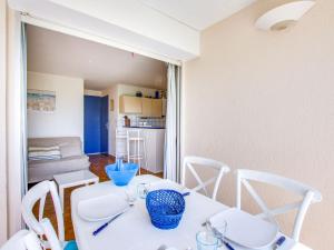 a dining room with a white table and chairs at Apartment Les terrasses de la Plage-1 by Interhome in Cap d'Agde