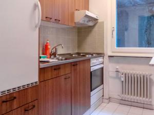 cocina con armarios de madera, fregadero y ventana en Apartment Kondor by Interhome, en Zermatt