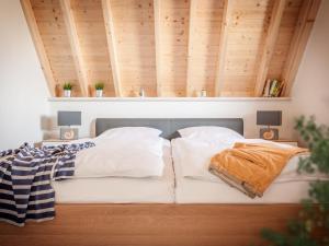 ドルム・ノイフェルトにあるHoliday Home Cuxland Ferienpark-3 by Interhomeの木製の天井の客室のベッド1台分です。