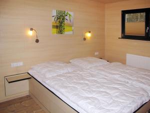 a large white bed in a room with two lights at Holiday Home Erzeberg-2 by Interhome in Balhorn