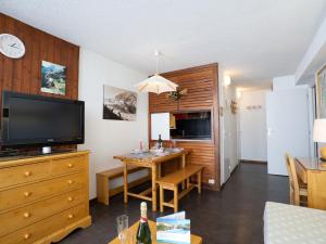 a living room with a dining room table and a television at Apartment Le Borsat-4 by Interhome in Tignes