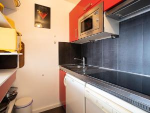 een keuken met een wastafel en een magnetron bij Apartment Le Borsat-4 by Interhome in Tignes
