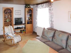 a living room with a couch and a tv at Holiday Home Triendl by Interhome in Bischofsmais