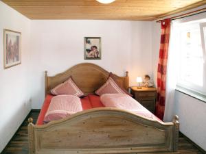 1 dormitorio con 1 cama de madera y 2 almohadas en Holiday Home Triendl by Interhome, en Bischofsmais