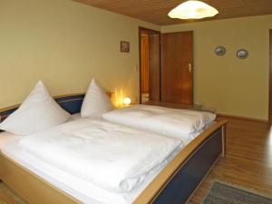 a large bed with white sheets and pillows on it at Apartment Irene by Interhome in Lohberg