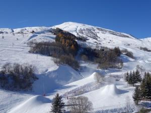 uma colina coberta de neve com árvores e uma montanha em Apartment Lunik Orion-18 by Interhome em Le Corbier