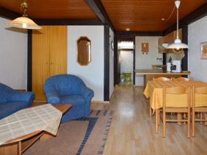 uma sala de estar com uma mesa de jantar e cadeiras azuis em Holiday Home Jägerwiesen - WAH104 by Interhome em Waldkirchen