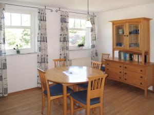 a dining room with a wooden table and chairs at Apartment Juliusruh-4 by Interhome in Juliusruh