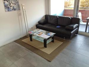 Sala de estar con sofá negro y mesa de centro en Apartment Bletilla by Interhome, en Locarno