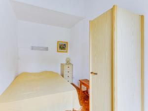 a bedroom with a bed and a dresser and a door at Apartment Les Mas de la Garrigue I et II-1 by Interhome in Cap d'Agde