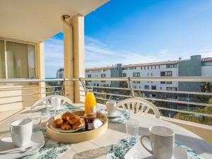a table with a plate of food on a balcony at Apartment La Palme d'Or-5 by Interhome in Cap d'Agde