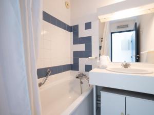 a bathroom with a sink and a bath tub and a sink at Apartment La Palme d'Or-5 by Interhome in Cap d'Agde