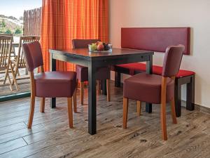 einen Esstisch mit Stühlen und einen Tisch mit Obst darauf in der Unterkunft Holiday Home Dünenhaus Familia Comfort by Interhome in Großpösna
