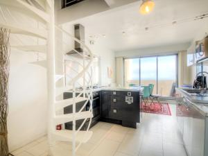 a kitchen with a staircase in the middle of a room at Apartment De La Plage-3 by Interhome in Cap d'Agde
