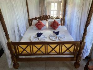 een bed met vier kussens en bogen erop bij Flamingo Guest house in Unawatuna