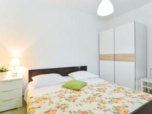 ein Schlafzimmer mit einem Bett mit einem grünen Kissen darauf in der Unterkunft Apartment Lila by Interhome in Mirce