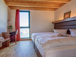 a bedroom with a bed and a desk and a window at Holiday Home Hafenhaus by Interhome in Großpösna