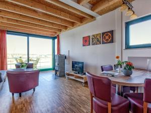 a living room with a table and chairs and a television at Holiday Home Hafenhaus by Interhome in Großpösna +11 photos