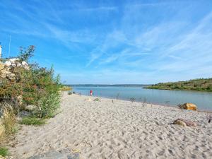 a sandy beach next to a body of water at Holiday Home Hafenhaus by Interhome in Großpösna