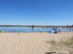 a group of people on a beach with a body of water at Holiday Home Dünenhaus Comfort by Interhome in Großpösna