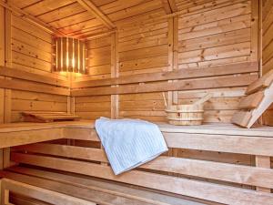 a wooden sauna with a bench in it at Holiday Home Dünenhaus Comfort by Interhome in Großpösna