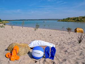 a pair of flip flops and a beach ball on a beach at Holiday Home Dünenhaus Comfort by Interhome in Großpösna