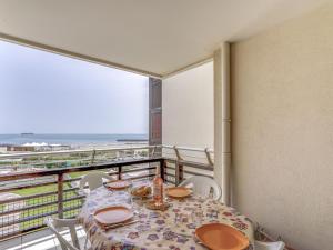 a table and chairs with a view of the ocean at Apartment Le Sunset-Cap Sud-12 by Interhome in Cap d'Agde