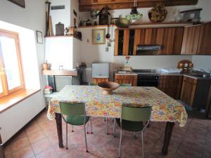 una cucina con tavolo, sedie e tovaglia di Holiday Home Cascina Ulivi by Interhome a Belmonte