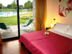 Marmirolo的住宿－科爾特狂歡節農莊酒店，一间卧室配有一张床,享有游泳池的景色