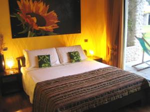 1 dormitorio con 1 cama con una pintura floral en la pared en Agriturismo Corte Carnevale en Marmirolo