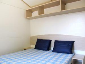 a small room with a bed with blue pillows at Holiday Home Cisano & San Vito-1 by Interhome in Lazise +24 photos