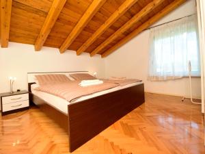 a large bed in a room with a wooden ceiling at Apartment Anica by Interhome in Pridraga