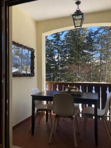 een eetkamer met een tafel en stoelen en een raam bij Sankt Moritz Dorf Charme Apartment in St. Moritz