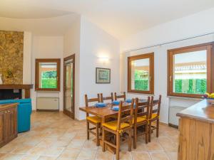 eine Küche und ein Esszimmer mit einem Holztisch und Stühlen in der Unterkunft Holiday Home Rei Sole - REI303 by Interhome in Costa Rei