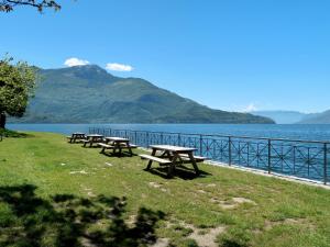 a row of picnic tables in front of a lake at Apartment Betti by Interhome in Domaso