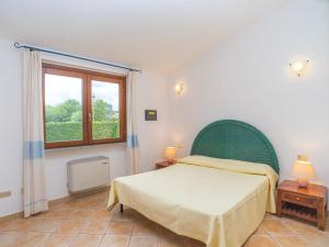 Schlafzimmer mit einem Bett und einem Fenster in der Unterkunft Holiday Home Rei Sole - REI303 by Interhome in Costa Rei