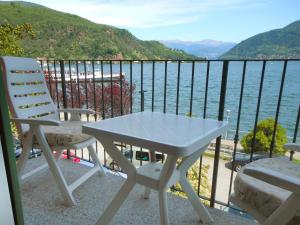 una mesa y sillas en un balcón con vistas al agua en Apartment Franco by Interhome, en Porto Ceresio