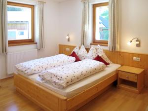 a bedroom with two beds and two windows at Apartment Obermüllerhof-2 by Interhome in Maranza
